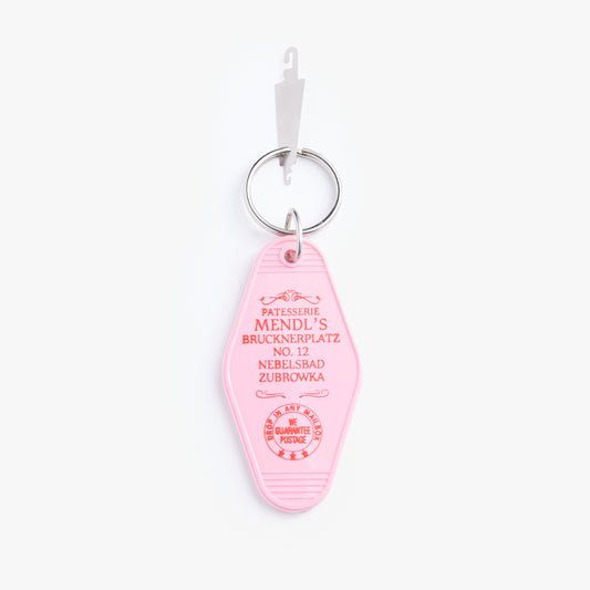 Pink keychain tag with text on a white background