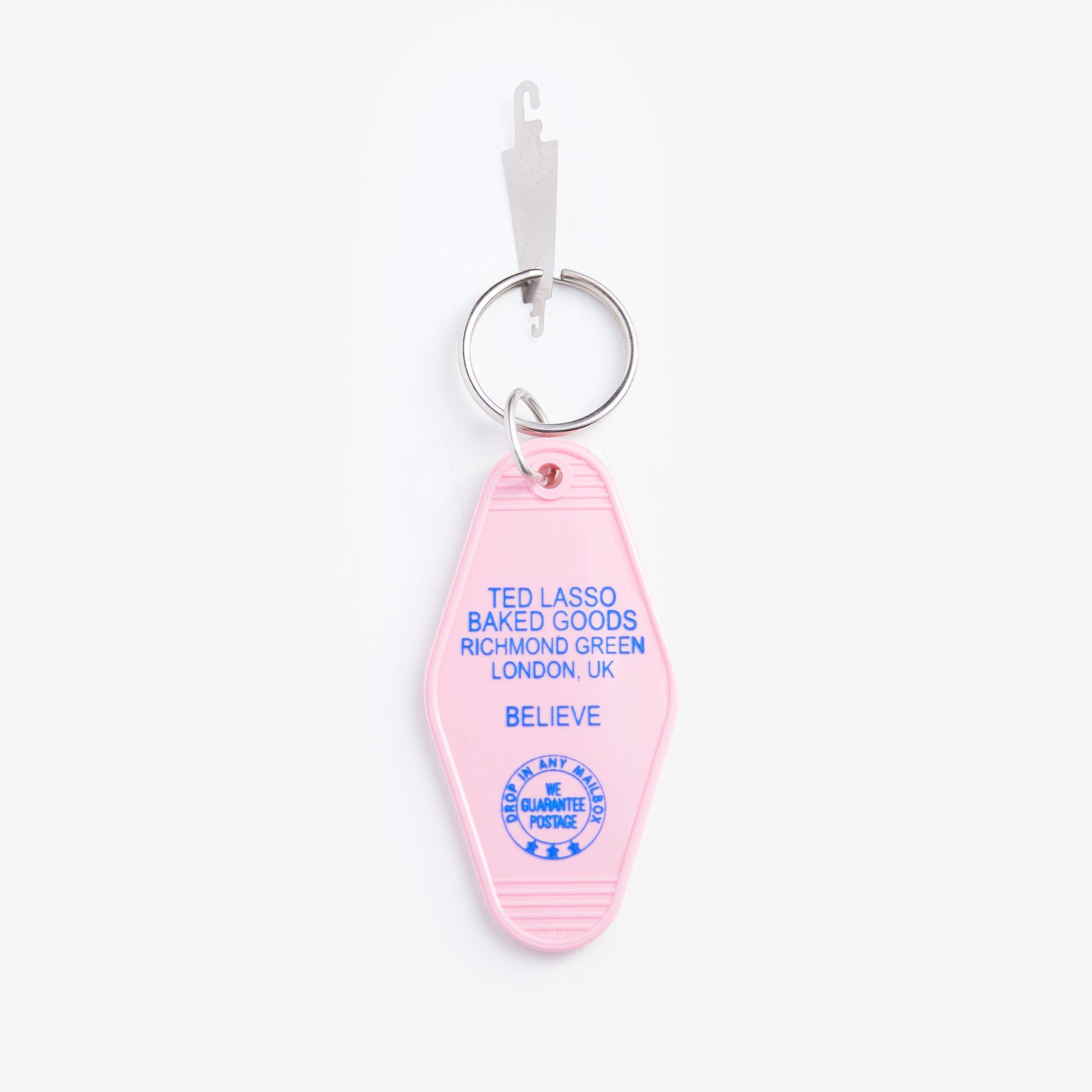 Pink keychain with blue text on a white background