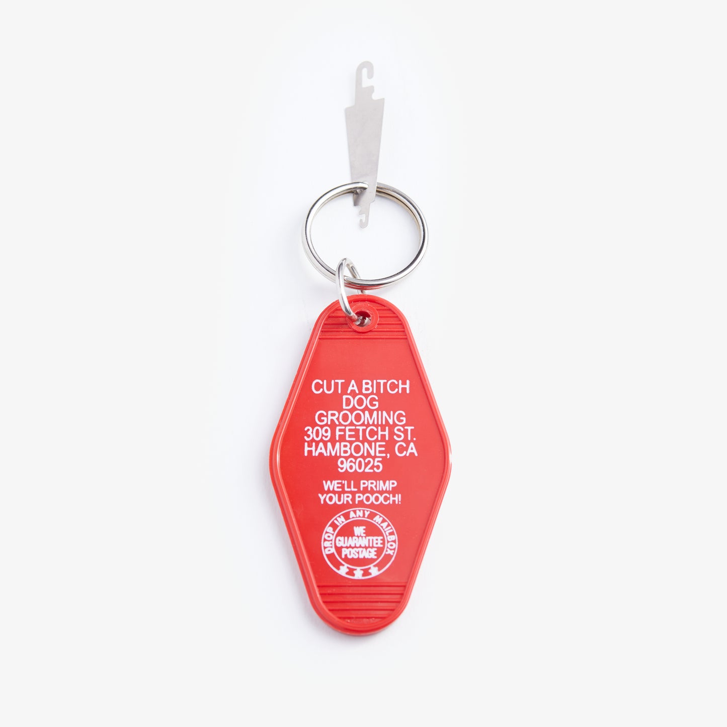 Red keychain with white text on a white background