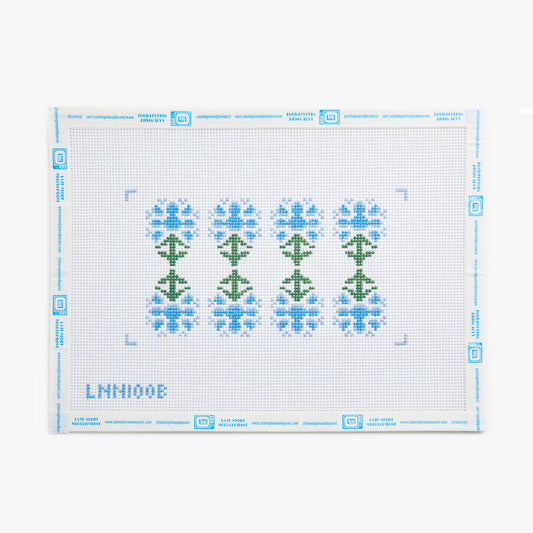 Cross-stitch pattern with green trees and blue flowers on a white background