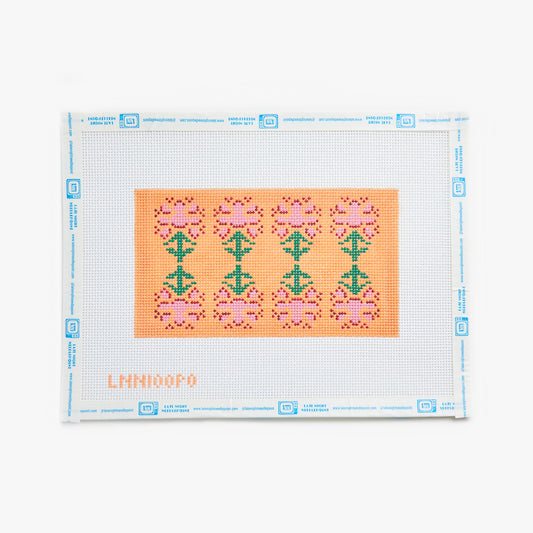 Cross-stitch pattern on a white fabric with a clear plastic sheet, featuring pink and green designs.