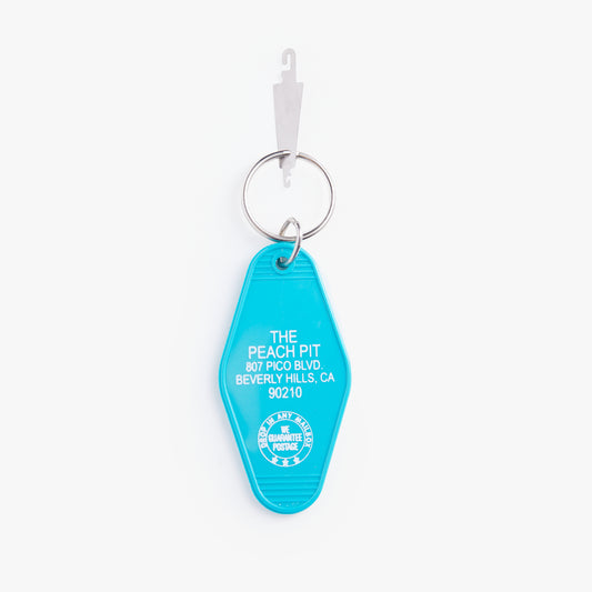 Turquoise keychain with white text on a white background