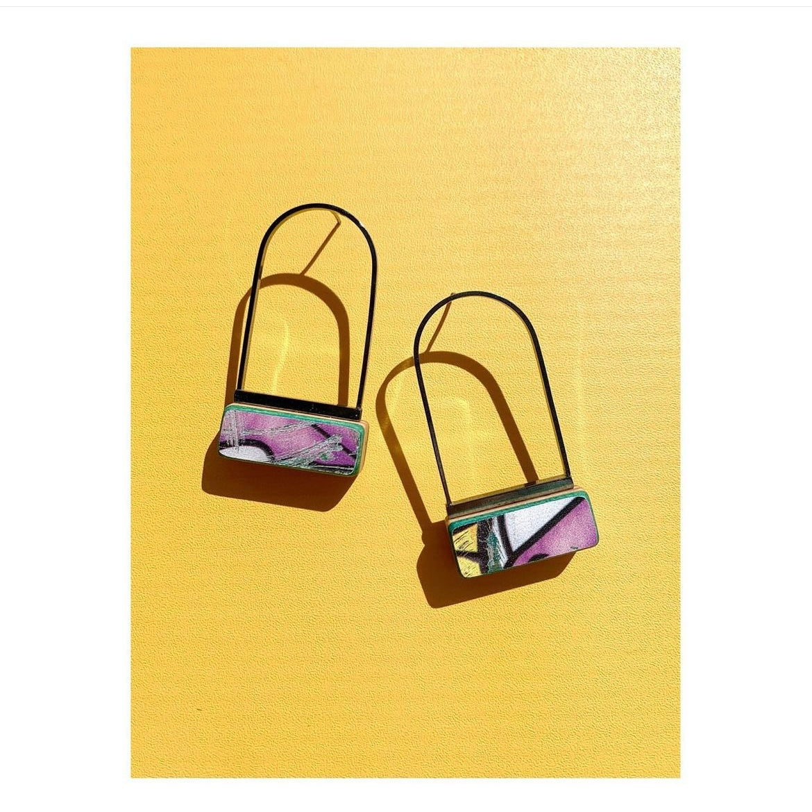Colorful earrings on a yellow background.